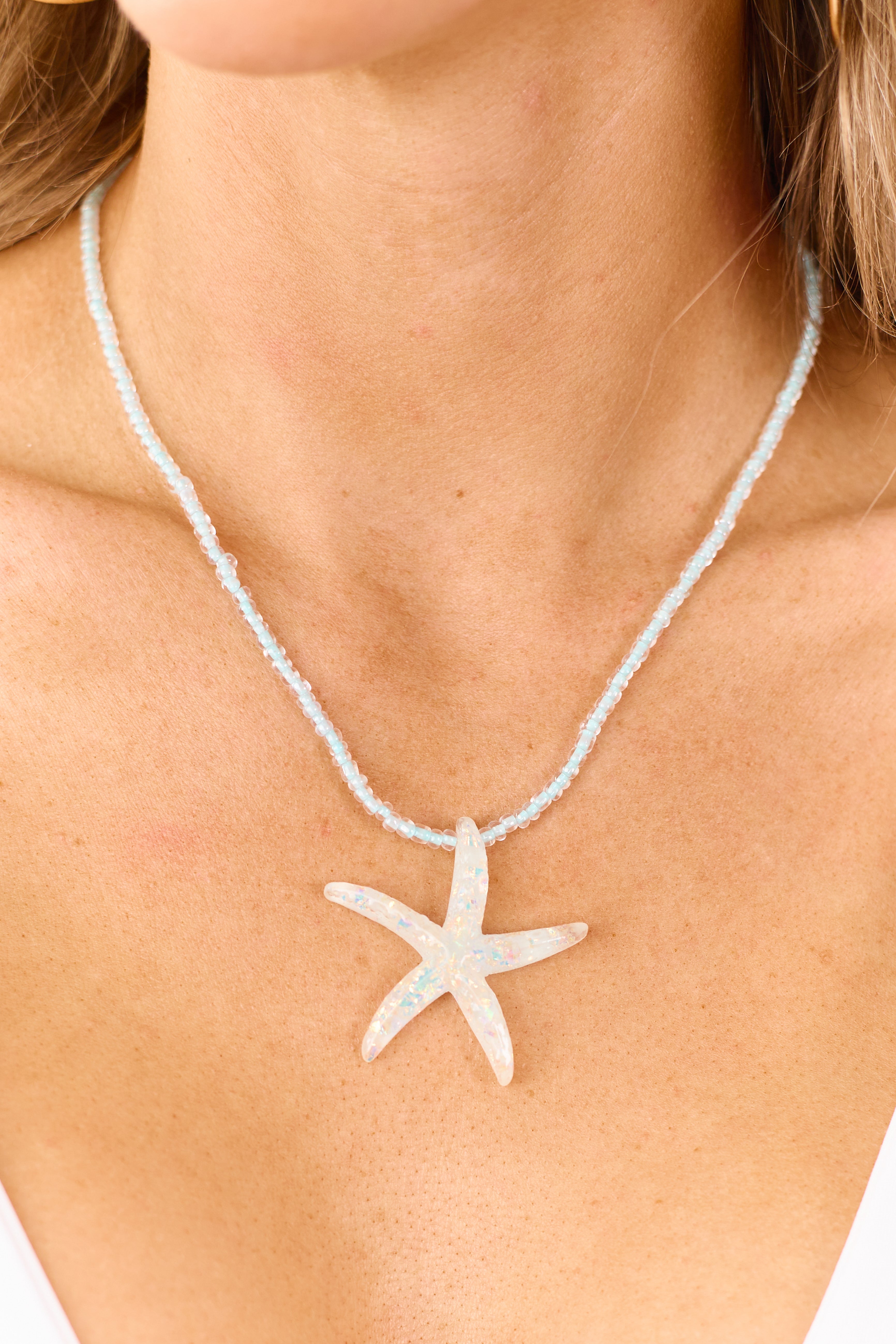 Collar con colgante de estrella de mar iridiscente con cuentas de color azul ártico