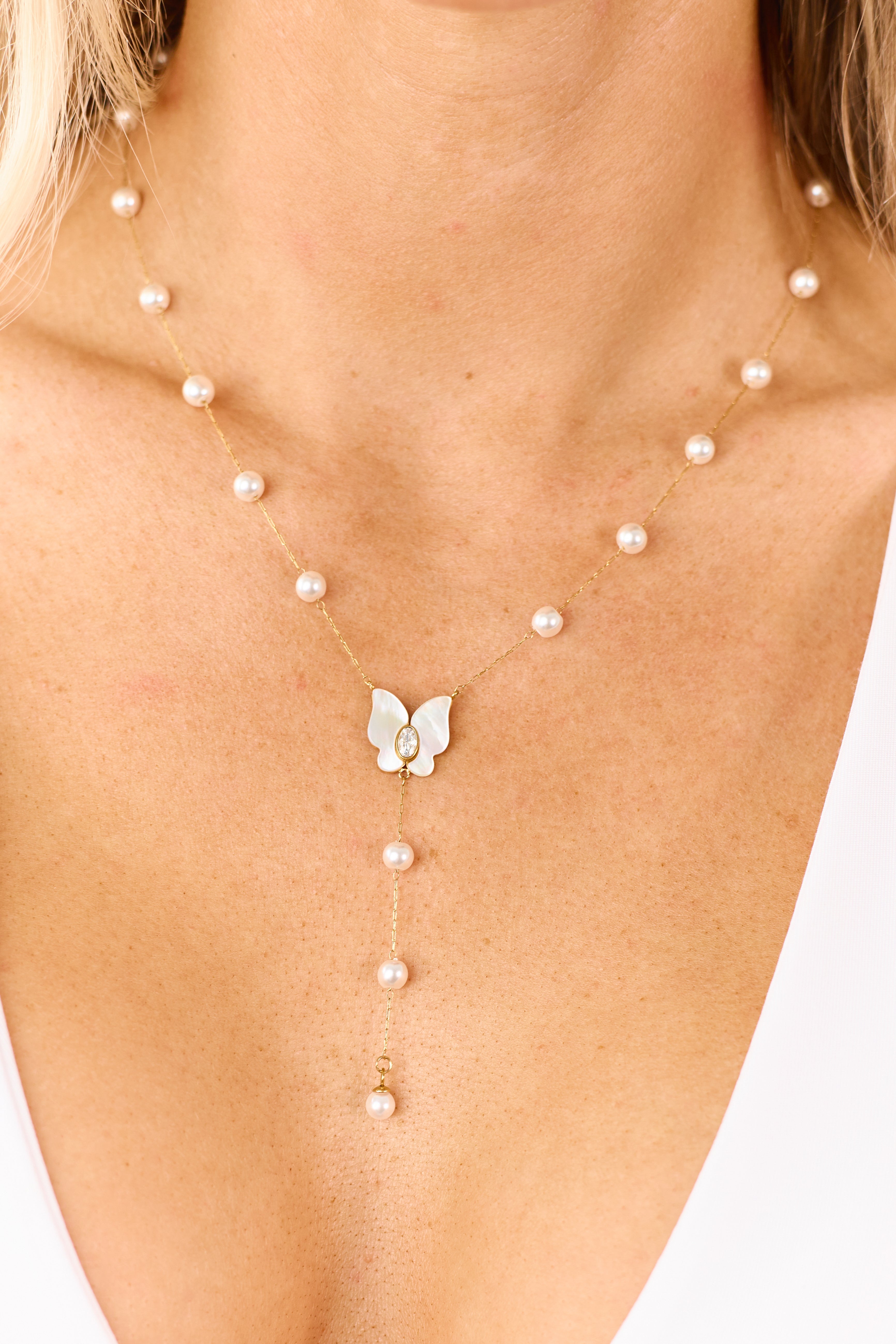 Elegante collar con colgante de mariposa y perla dorada