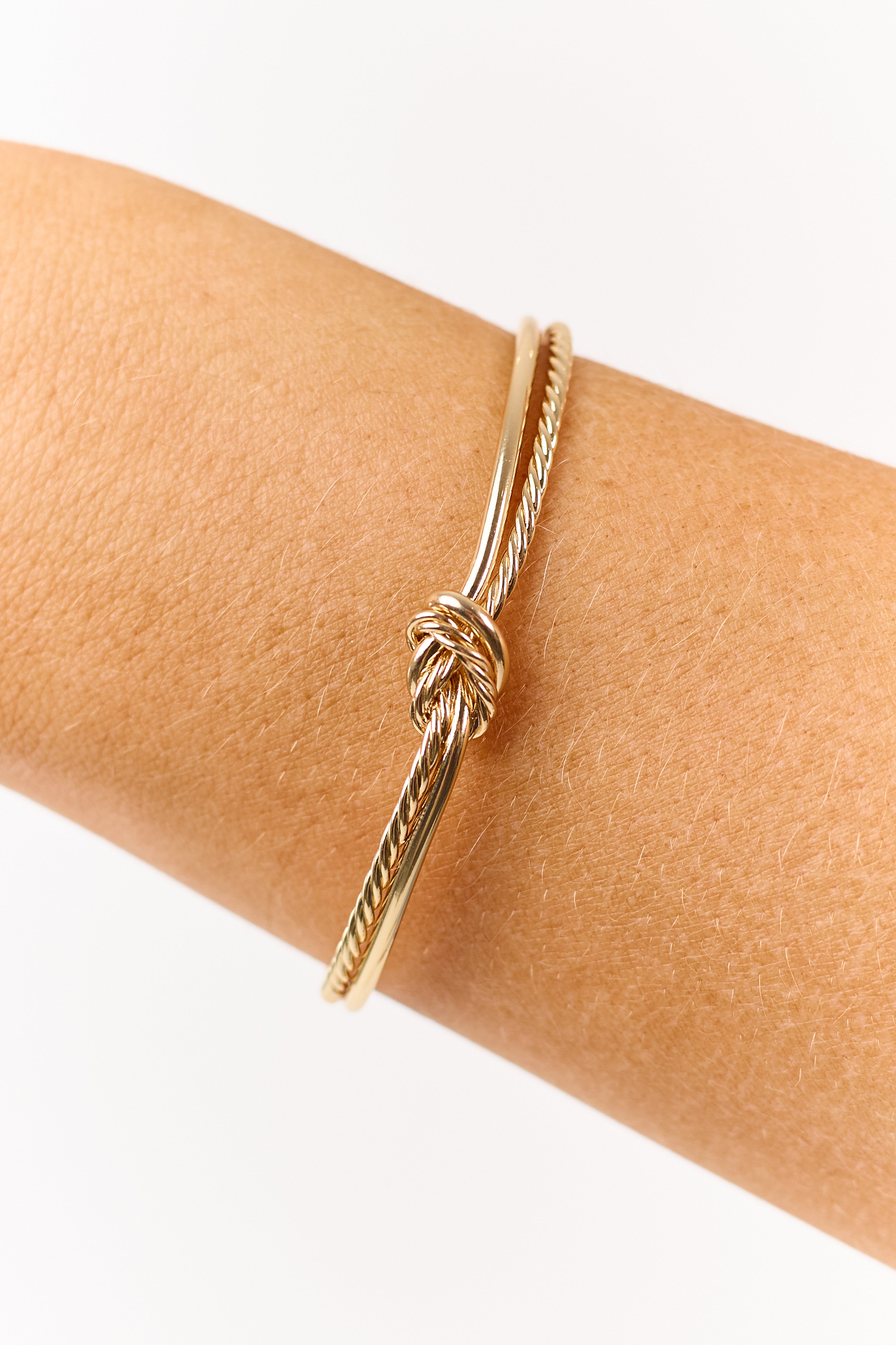 Pulsera dorada con nudo de cuerda y puño abierto