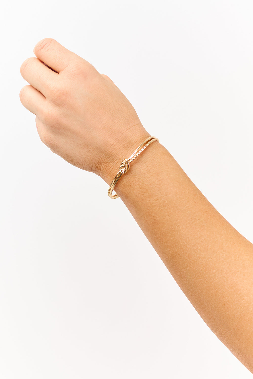 Pulsera dorada con nudo de cuerda y puño abierto