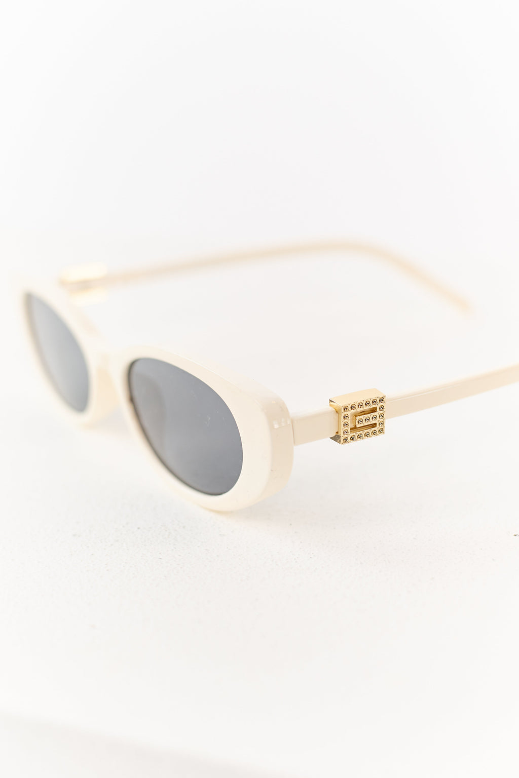 Gafas de marco ovalado color marfil con acento metálico elegante