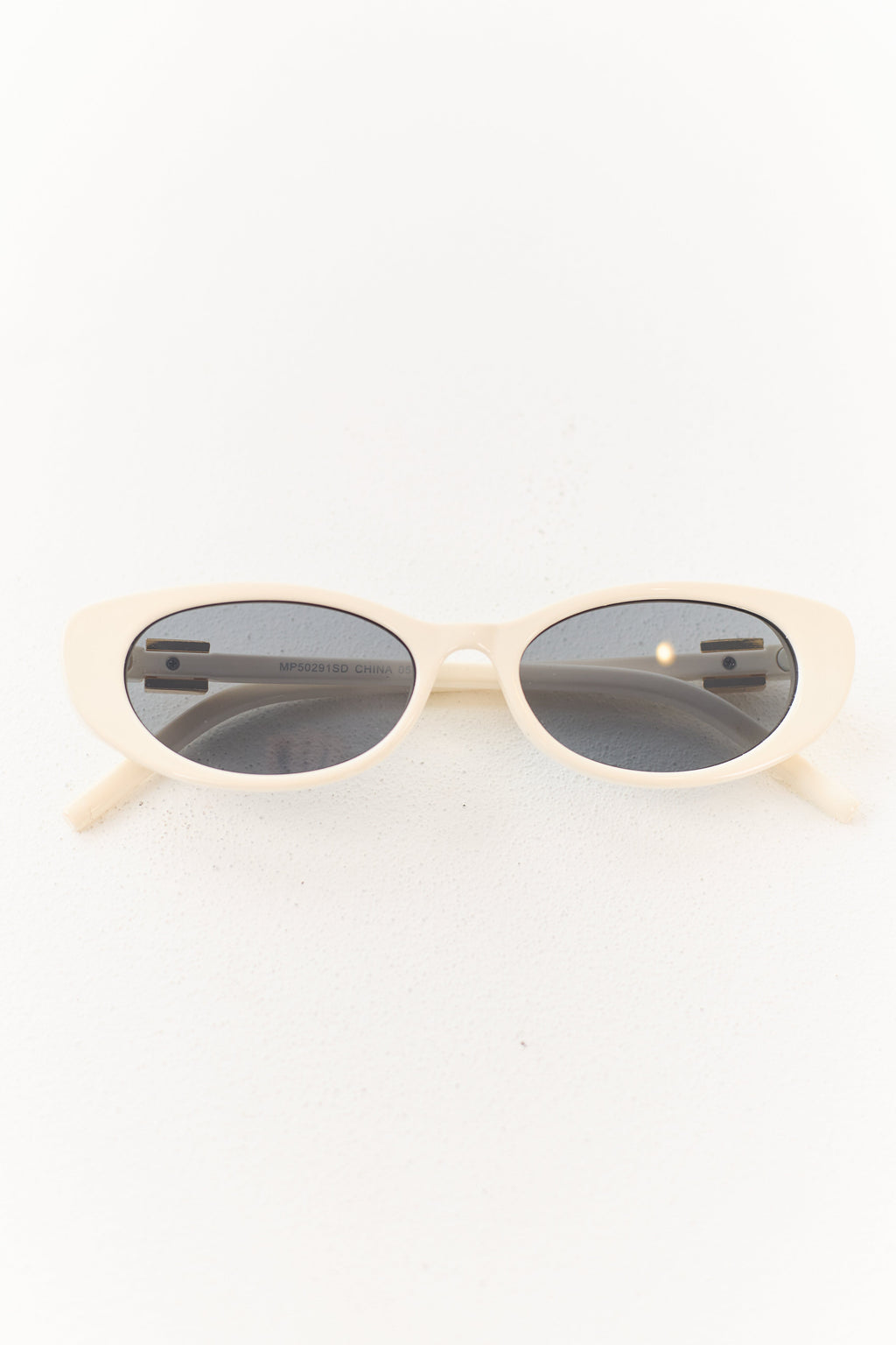 Gafas de marco ovalado color marfil con acento metálico elegante