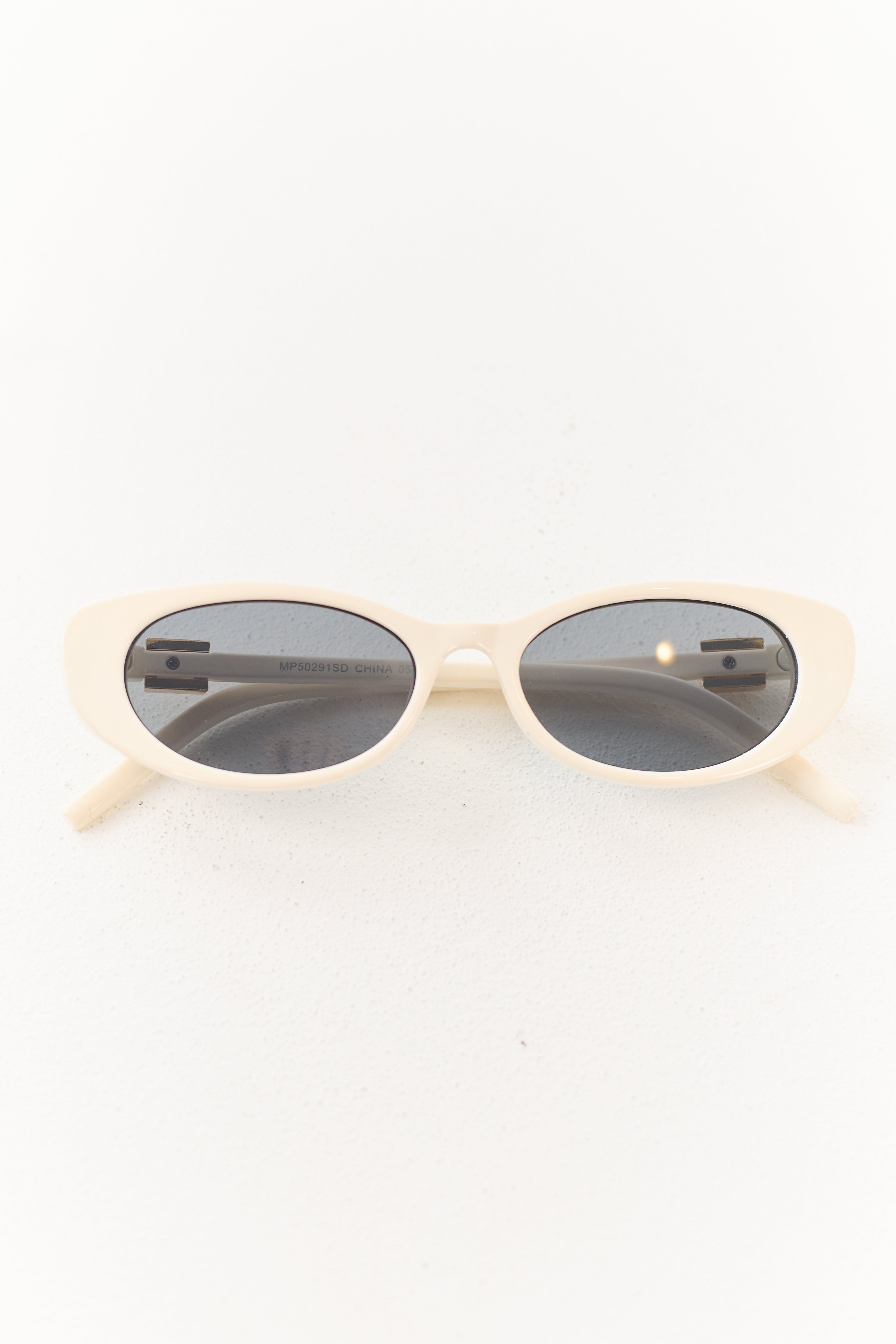 Gafas de marco ovalado color marfil con acento metálico elegante